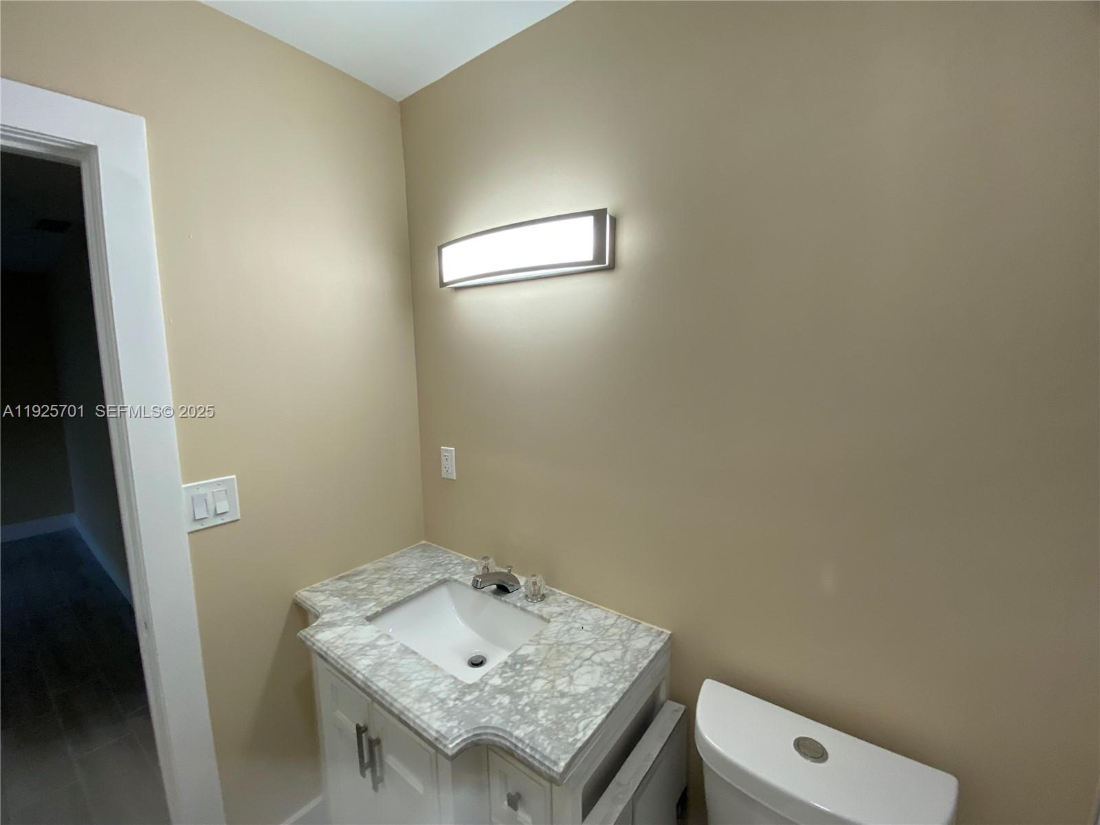 234 Northeast 55th Terrace Miami, FL 33137 - Photo 8 of 22 a bathroom with a sink toilet and mirror