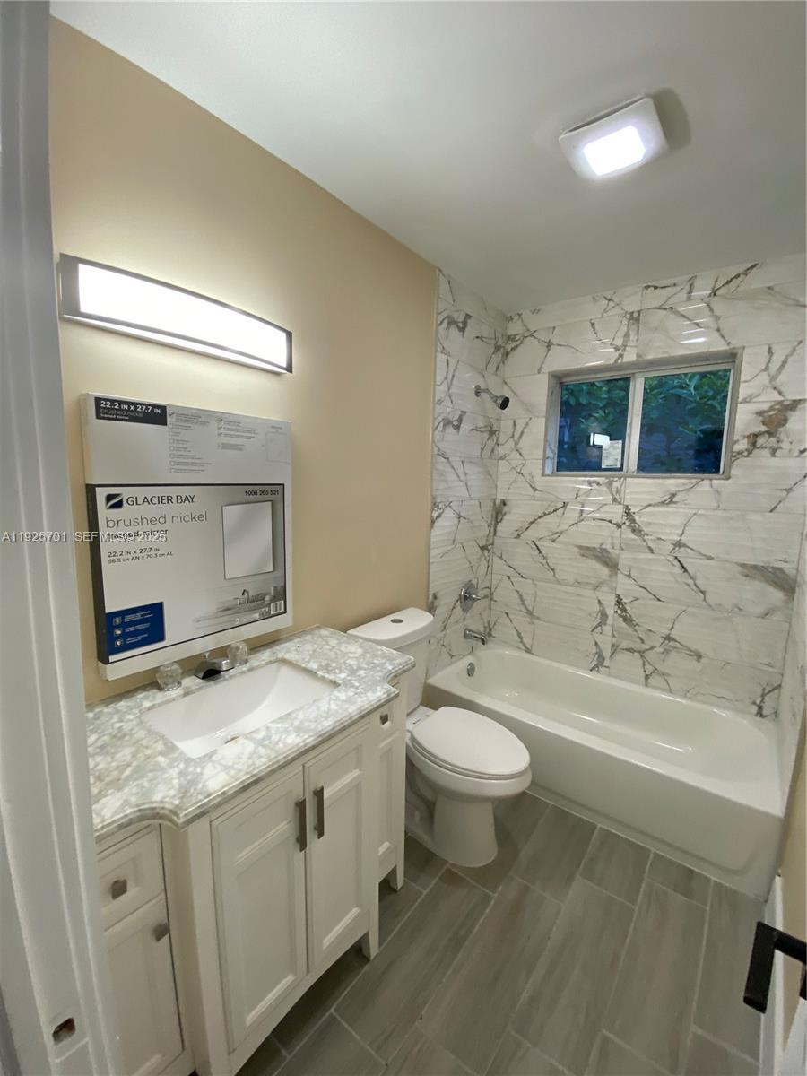234 Northeast 55th Terrace Miami, FL 33137 - Photo 10 of 22 a bathroom with a granite countertop toilet sink and mirror