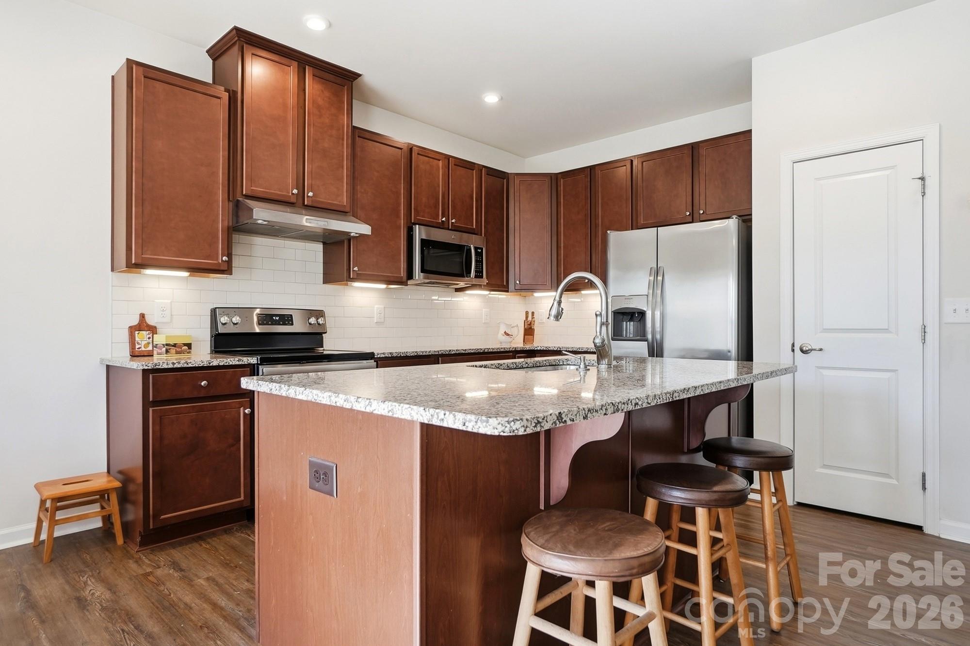 1842 Slippery Rock Lane Monroe, NC 28112 - Photo 5 of 25 a kitchen with stainless steel appliances granite countertop a sink a stove a refrigerator cabinets and a dining table