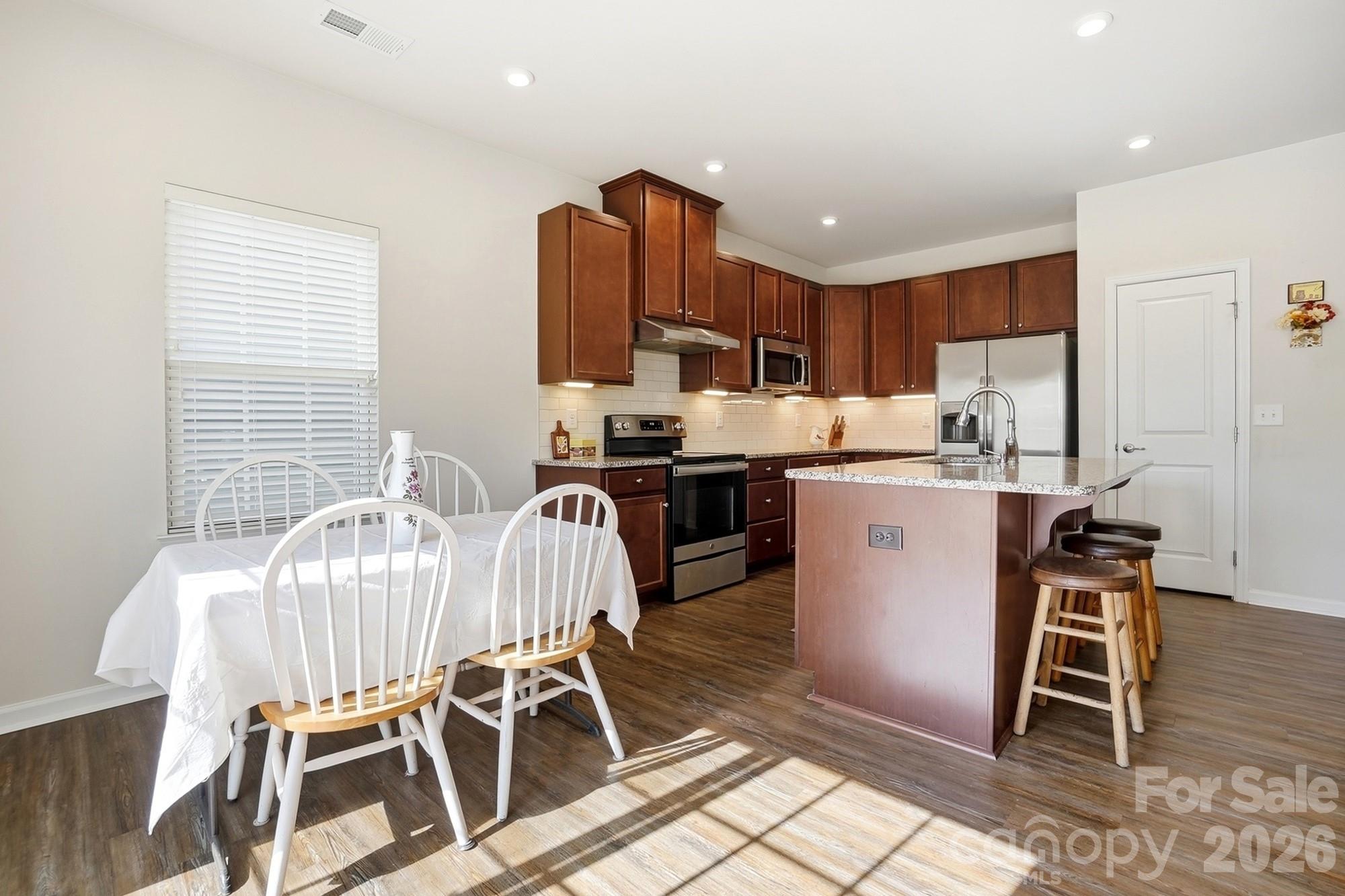 1842 Slippery Rock Lane Monroe, NC 28112 - Photo 6 of 25 a view of a dining room with furniture and wooden floor