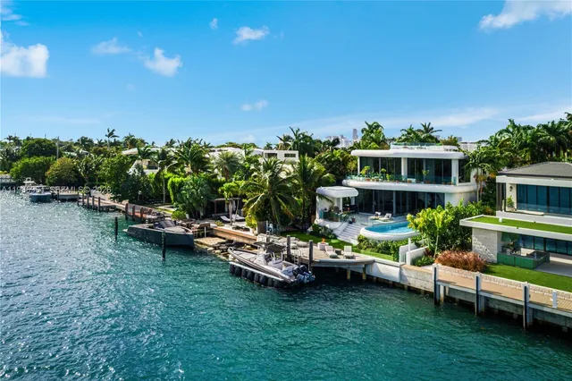 a view of a house with table and chairs under an umbrella