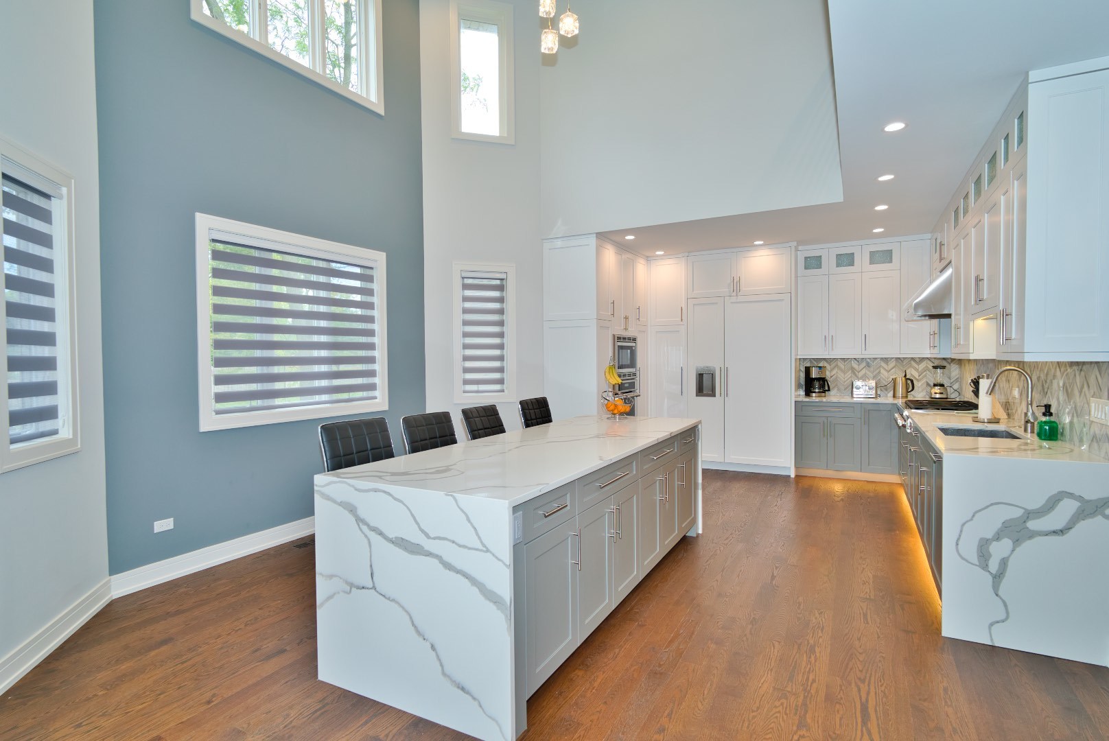 210 Cottonwood Road Northbrook, IL 60062 - Photo 24 of 47 a large kitchen with kitchen island a stove a sink a refrigerator and white cabinets with wooden floor
