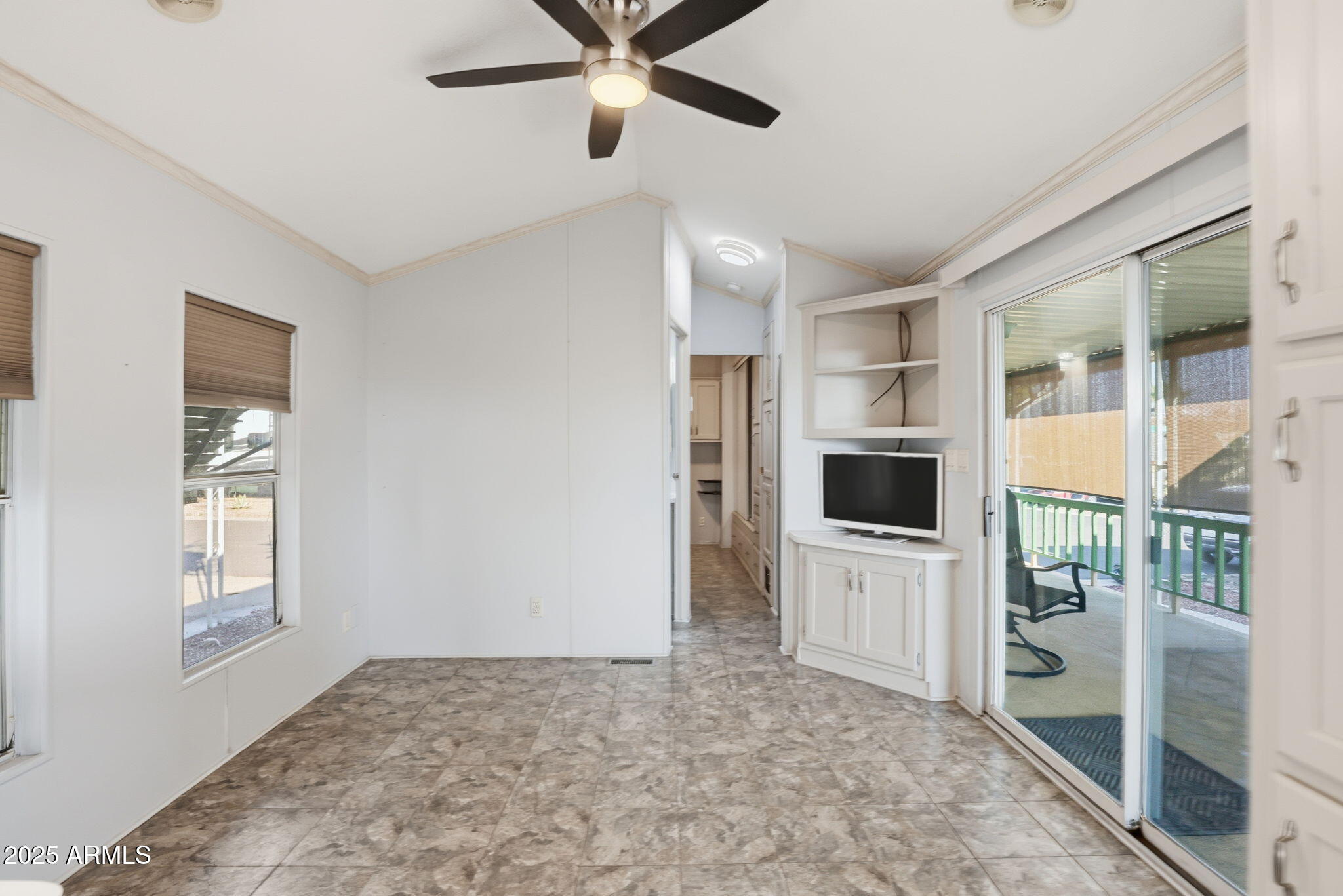11201 North El Mirage Road, Unit 720 El Mirage, AZ 85335 - Photo 24 of 43 a view of a livingroom with a flat screen tv wooden floor and a ceiling fan