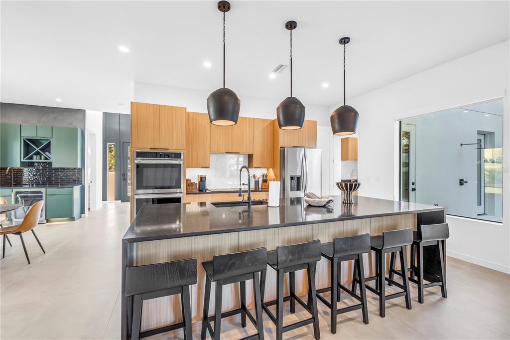 2305 Temple Street Sarasota, FL 34239 - Photo 16 of 64 a kitchen with stainless steel appliances granite countertop a stove a kitchen island a sink and chairs