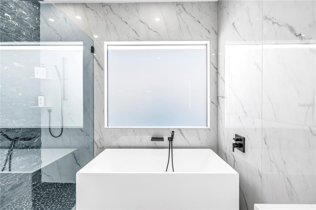 2305 Temple Street Sarasota, FL 34239 - Photo 24 of 64 a bathroom with a tub a sink and a shower