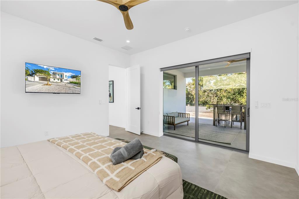 2305 Temple Street Sarasota, FL 34239 - Photo 49 of 64 a bedroom with a balcony a bed and a painting on the wall