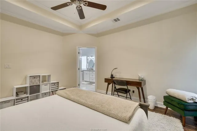 a bedroom with a large bed and a chandelier