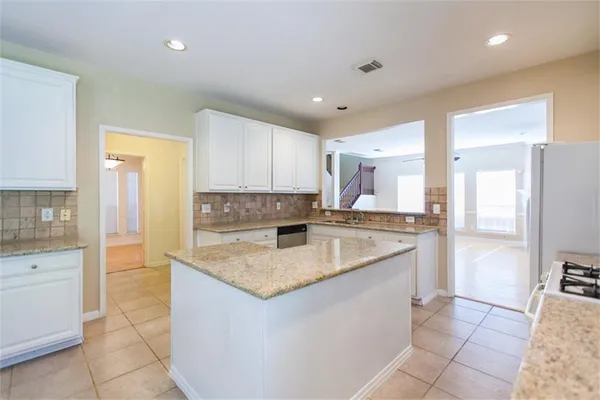 a kitchen with a sink refrigerator and cabinets