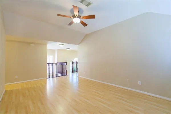 a view of a room with wooden floor and ceiling fan
