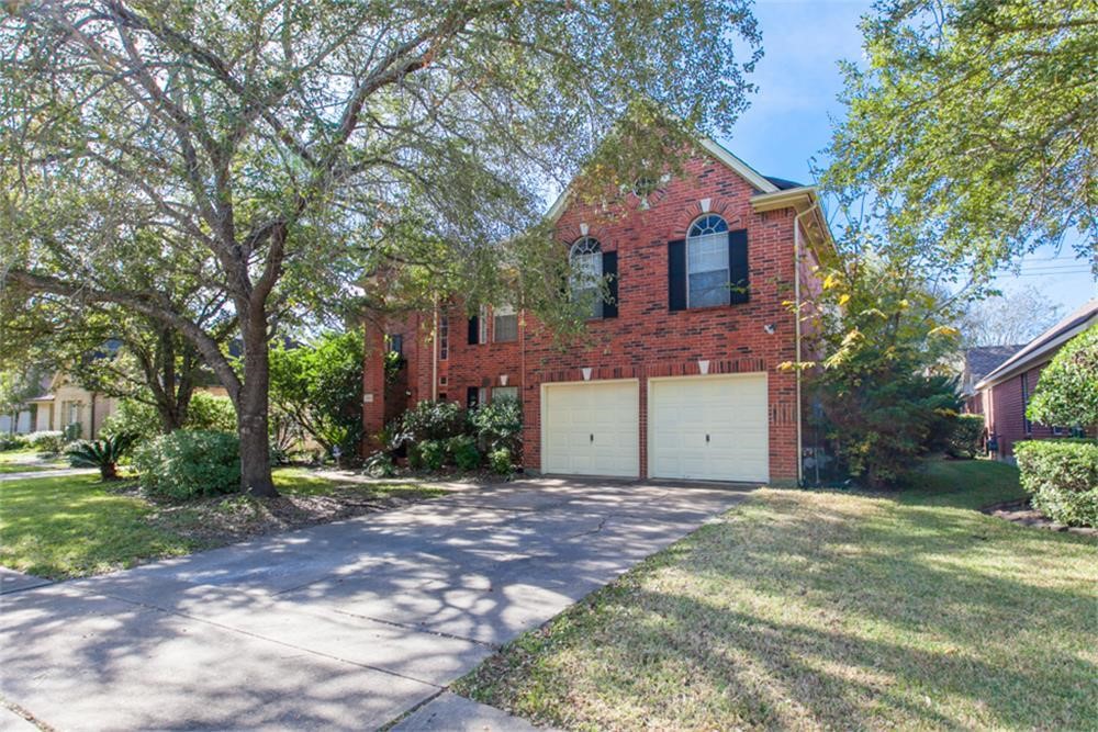 13630 Country Green Court Houston, TX 77059 - Photo 2 of 30 a front view of a house with a garden