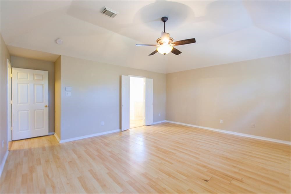 13630 Country Green Court Houston, TX 77059 - Photo 24 of 30 a view of an empty room with wooden floor and a ceiling fan