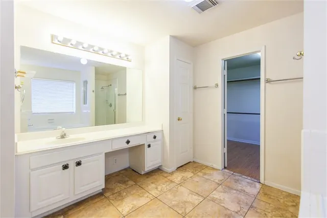 a spacious bathroom with a double vanity sink a mirror and a shower