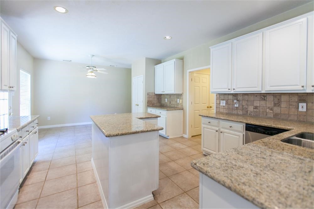 13630 Country Green Court Houston, TX 77059 - Photo 9 of 30 a kitchen with granite countertop a sink and a stove top oven