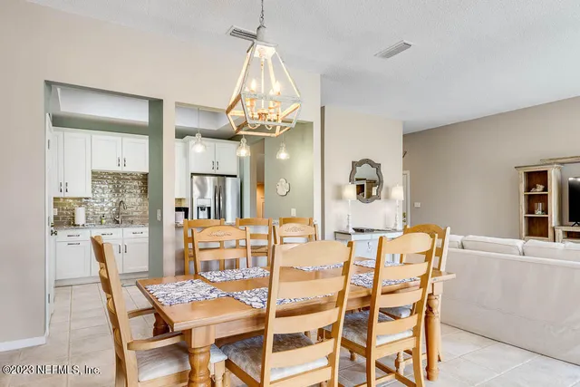 a dining room with furniture a chandelier and wooden floor