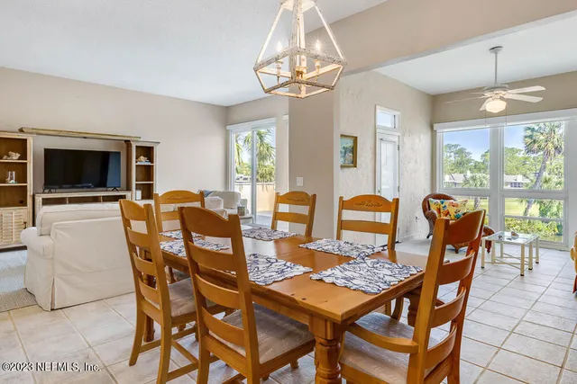 a dining room with furniture a chandelier and window