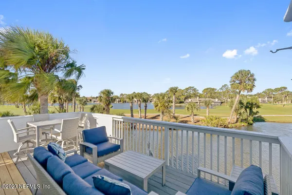 a view of a balcony with table and chairs and wooden fence