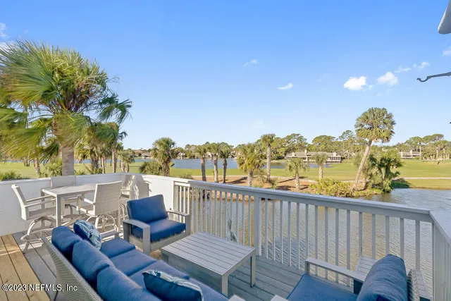 a view of a balcony with table and chairs and wooden fence