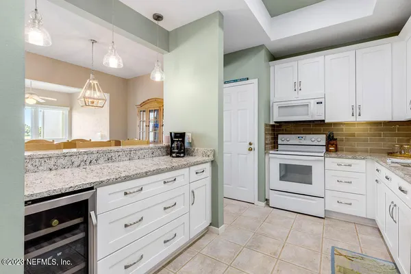 a kitchen with granite countertop white cabinets and stainless steel appliances