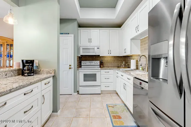 a kitchen with stainless steel appliances granite countertop a refrigerator sink and stove