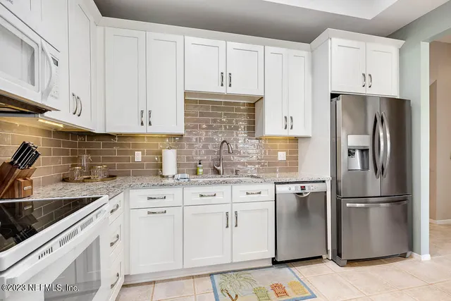 a kitchen with appliances a sink and cabinets