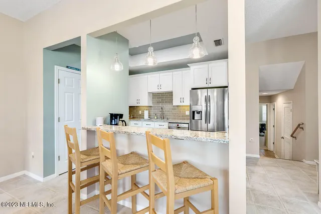 a kitchen with stainless steel appliances kitchen island granite countertop a refrigerator and microwave