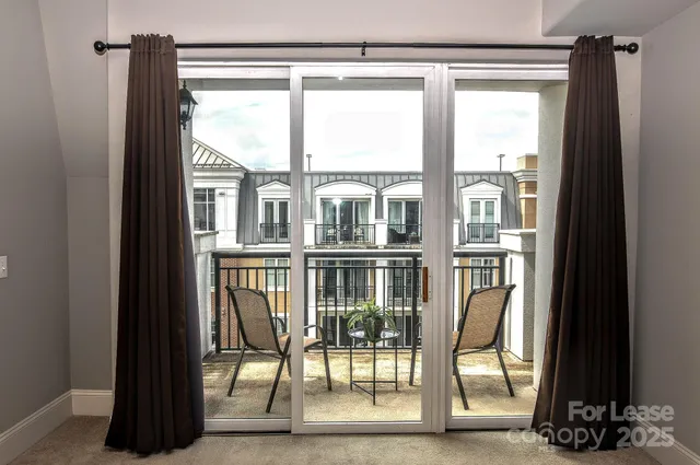 a view of a balcony with chairs and floor to ceiling window