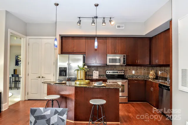 a kitchen with a refrigerator and a stove top oven