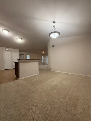 en empty room with windows and ceiling fan
