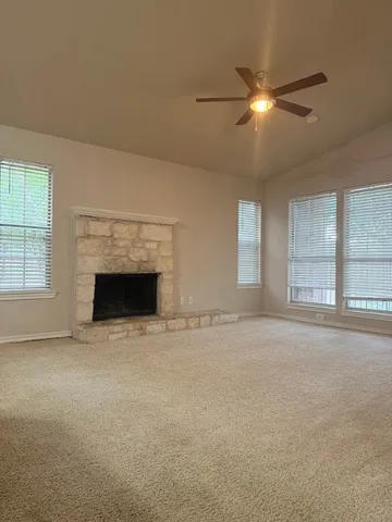 a view of an empty room with a fireplace and a window