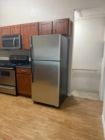 a kitchen with stainless steel appliances granite countertop a refrigerator and a stove