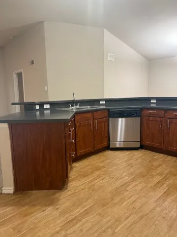 a view of a kitchen with stainless steel appliances granite countertop a sink and cabinets