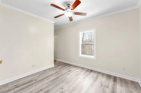 an empty room with a window and a ceiling fan