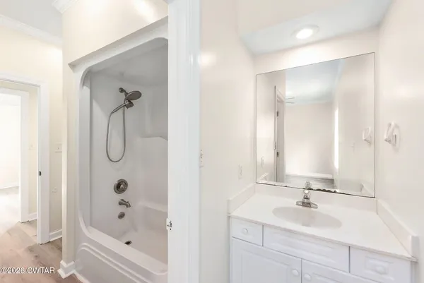 a bathroom with a tub sink and mirror