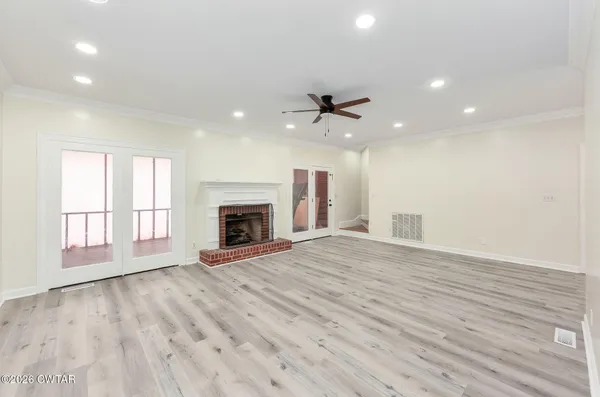 a view of an empty room with a fireplace and a window