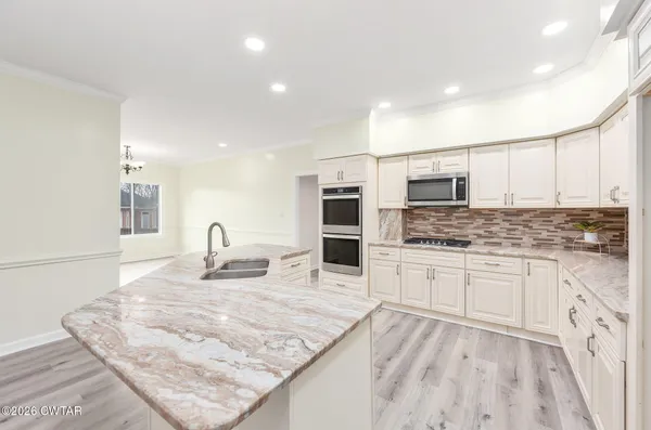 a kitchen with stainless steel appliances granite countertop a sink stove and oven