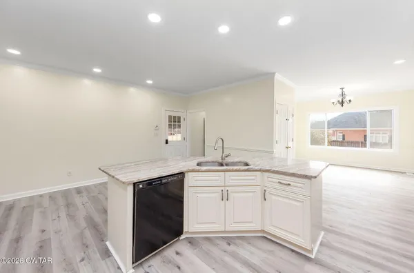 a kitchen with a sink cabinets and wooden floor