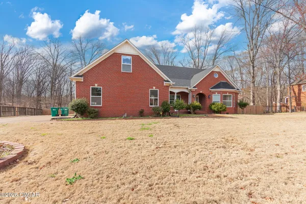 a front view of house with yard and trees around