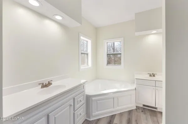 a bathroom with a tub sink and mirror