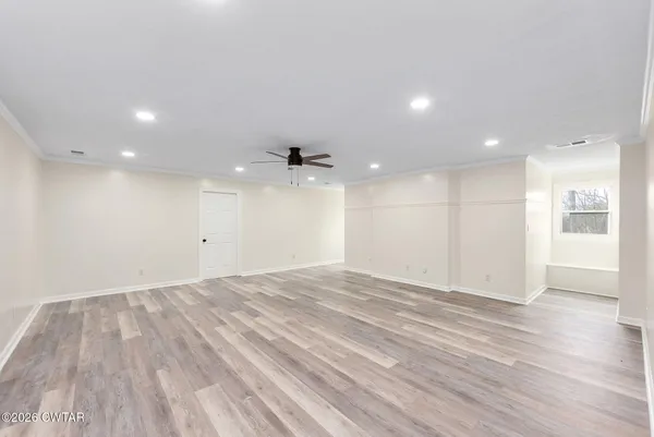 a view of an empty room with wooden floor