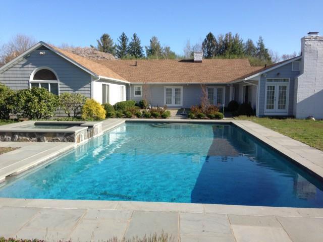 a front view of a house with swimming pool having outdoor seating