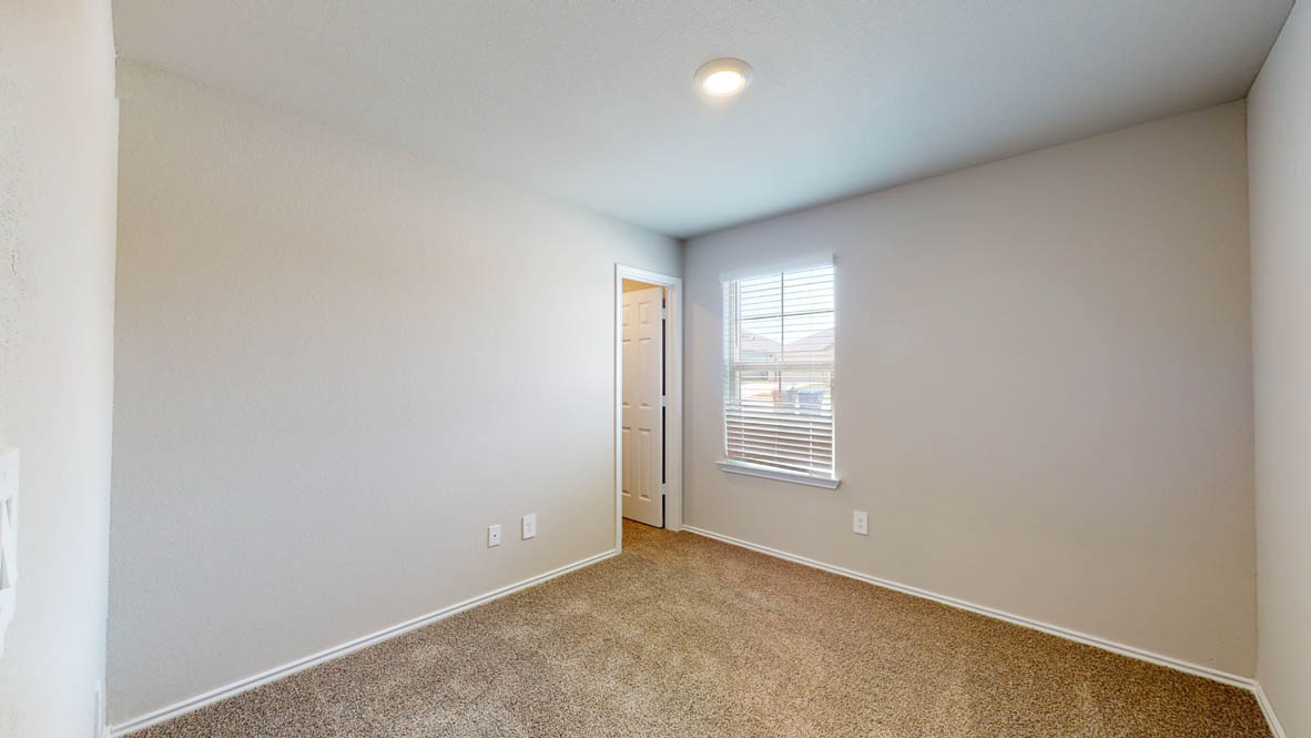 513 Hector Loop Georgetown, TX 78626 - Photo 9 of 12 An inviting secondary bedroom featuring plush carpeting and natural light filtering through the window.
