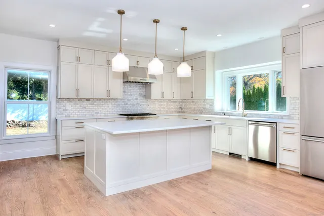 a kitchen with white cabinets and sink