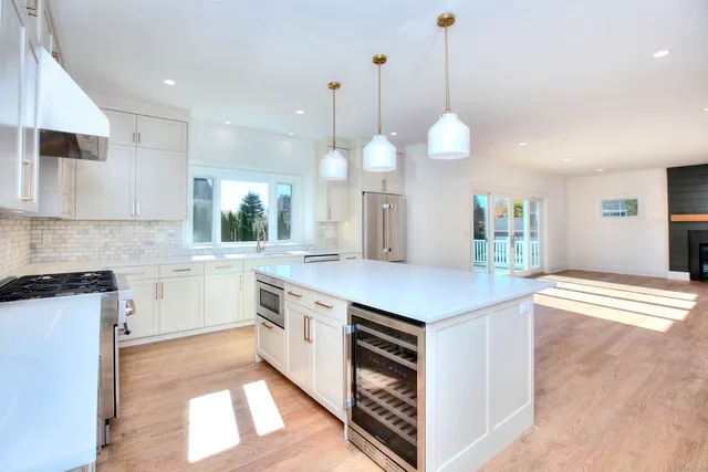 a kitchen with a stove a sink a center island and a wooden floor