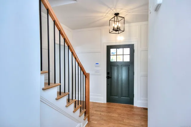a view of a hallway with wooden floor and staircase