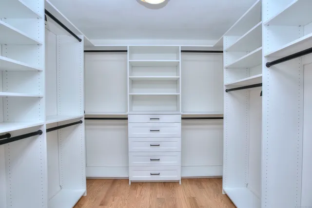 a view of walk in closet with empty racks