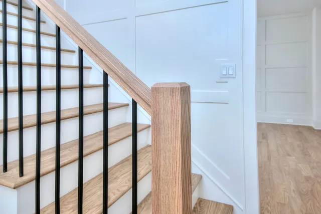 a view of staircase with railing and white walls