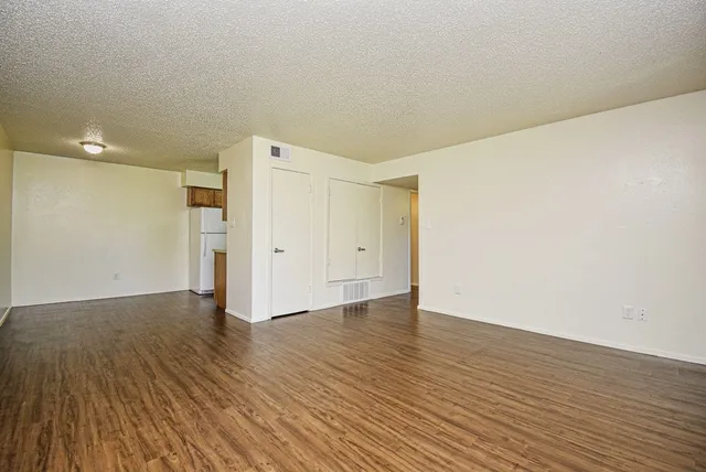 a view of an empty room with wooden floor