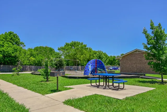 a garden with a bench and some trees