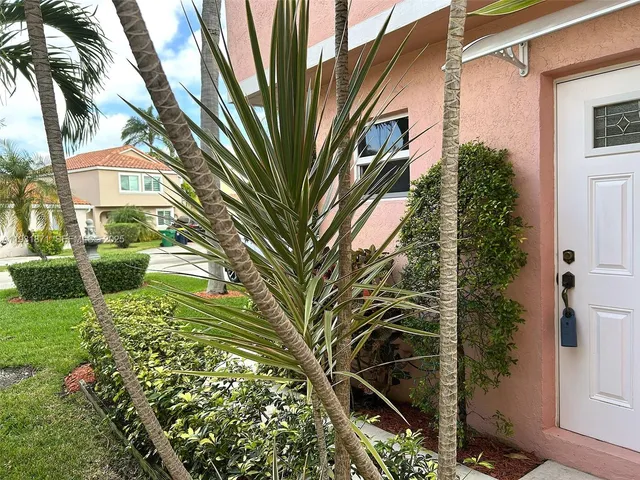 a view of a hallway with wooden floor and a bathroom
