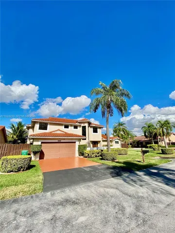 a front view of a house with a garden and houses
